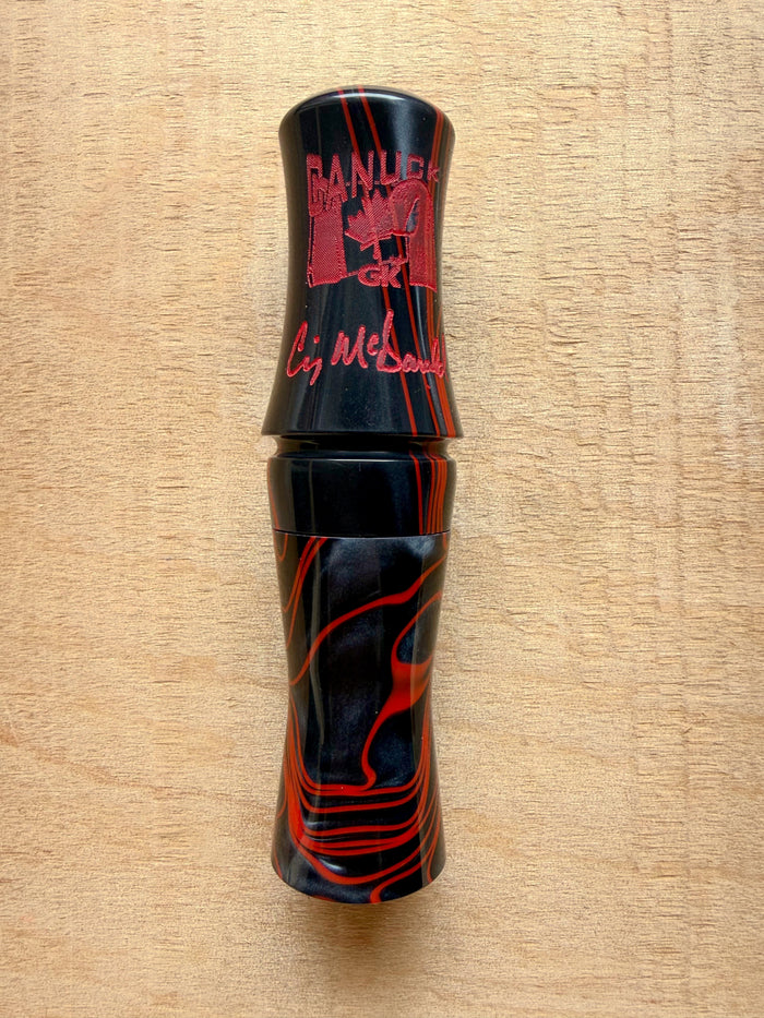 GK Calls Canuck short reed goose call in Midnight Rage, black with red swirl, lying on a wood board